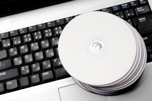 ノートPCのキーボードの上に置かれた複数枚のCD-R
