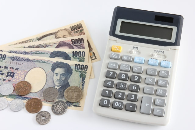 日本のお札、硬貨の横に置かれた計算機