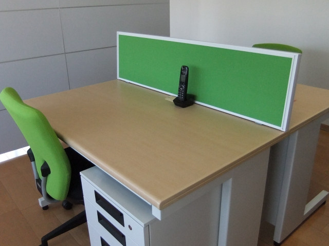 パーテーションで仕切られた向かい合わせのデスクと椅子